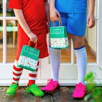 Two children holding a football party treat bag at a birthday party 